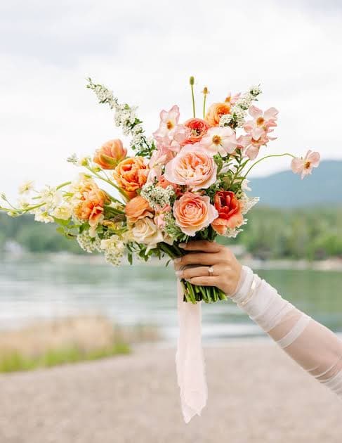 A hand holding a bridal bouquet